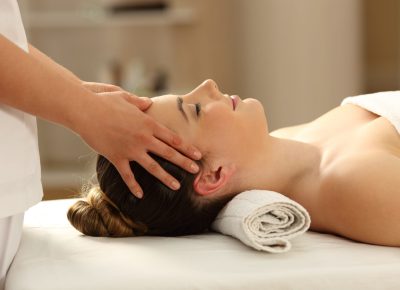 Side view portrait of a woman relaxing receiving a facial massage in a spa salon