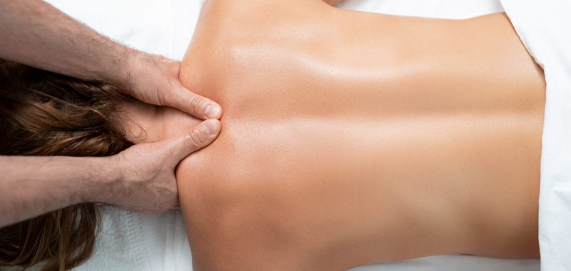 So soft and clean skin. Top view portrait of middle aged woman lying on massage table and receiving body treatment at modern spa salon