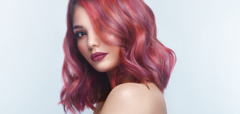 Beautiful girl with multi-colored hair and classic make-up and hairstyle. Beauty face. Photo taken in the studio