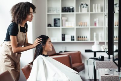 Young woman looking for changes, trying new hairstyle at beauty salon, empty space