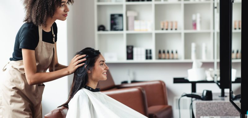 Young woman looking for changes, trying new hairstyle at beauty salon Young woman looking for changes, trying new hairstyle at beauty salon, empty space