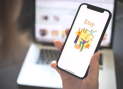 Kharkov, Ukraine - August 12, 2021: Etsy app. Woman using smartphone with etsy application. Brand logo