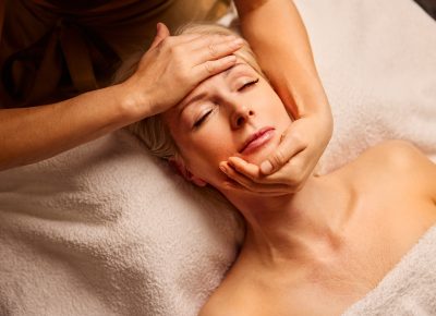 Femme recevant un massage Kobido du visage, soin anti-âge japonais favorisant relaxation et jeunesse de la peau.